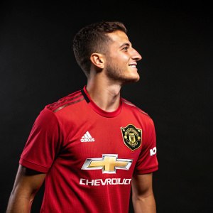 Diogo Dalot, dressed in Manchester United jersey, Chevrolet logo visible. Dark studio backdrop.