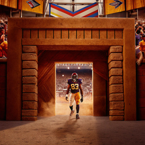 Marcus Davenport, football player from UTSA, posing in a vibrant stadium. Wearing jersey with number 93. Backdrop showcases diverse crowd and colorful banners advertising NFL Combine event in Indianapolis.
