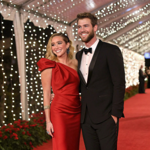 Miley Cyrus and Liam Hemsworth at the gala. Red carpet event. Glamorous backdrop with twinkling lights.