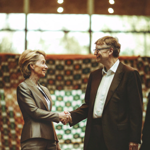 Formal photo of Ursula von der Leyen and Bill Gates shaking hands. Against vibrant, patterned backdrop at Goalkeepers event