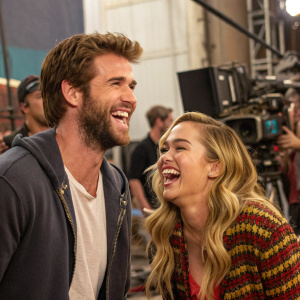 Liam Hemsworth and Miley Cyrus laughing together on the set of their latest movie.