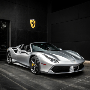 A stunning photo of a silver Ferrari 488 Spider on a sleek black background. The car features a sharp, aerodynamic design with bold lines and a sleek hood. It's parked in a luxurious setting, with the iconic Ferrari badge prominently displayed.