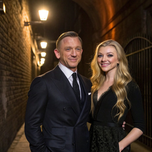 Daniel Craig, wearing a dark suit, and Natalie Dormer, with long blonde hair, posing against a backdrop of a dimly lit alley. They are at the premiere of their upcoming film.