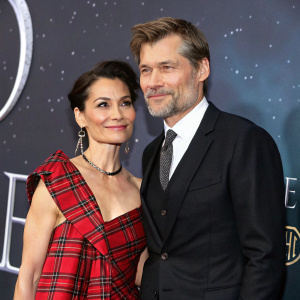 Nikolaj Coster-Waldau and Nukaaka Coster-Waldau at the premiere. Nikolaj in a black suit, Nukaaka in a daring tartan dress. The backdrop is dark and starry with galaxy prints.