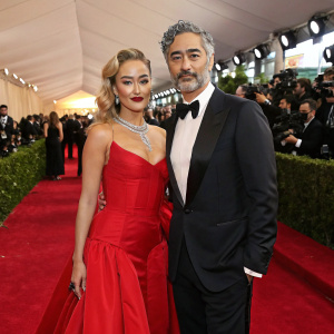 Rita Ora and Taika Waititi at a glitzy awards show. Red carpet event, bustling crowd in background