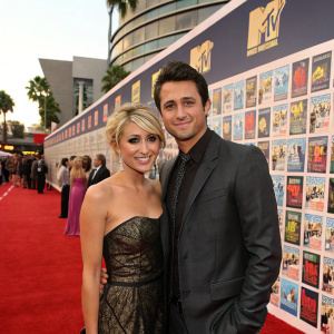 Chelsea Kane and Stephen Colletti standing in front of a giant movie poster wall. Posed for pictures during 2011 MTV Movie Awards event.
