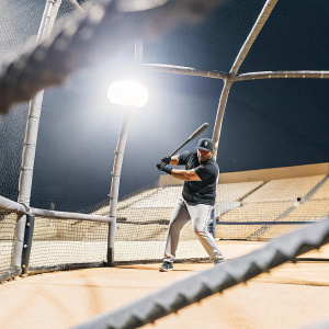 Yoan Moncada, Chicago White Sox player, in the batting cage. Bright stadium lights, empty seats
