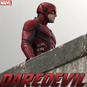 Daredevil, in red costume, standing in front of grey wall. Stone texture visible on lower part of suit. Marvel logo at bottom.