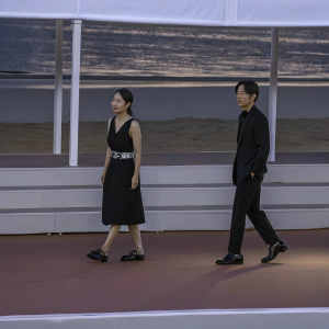 Jeon Do-Yeon and Kim Nam-Gil at Cannes Film Festival press conference. Both wearing formal attire, Jeon Do-Yeon in a black dress with belt, Kim Nam-Gil in a black suit.