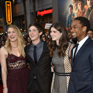 Leven Rambin, Douglas Smith, Logan Lerman, Alexandra Daddario, and Brandon T Jackson at a bustling movie premiere. Crowd and movie posters in the background.