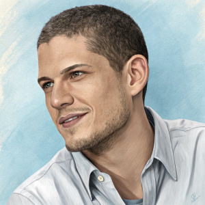 Close-up portrait of Wentworth Miller, Caucasian actor, with a slight stubble. Light blue background, dressed in casual light shirt. Friendly demeanor.