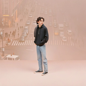 Timothée Chalamet, wearing a casual yet stylish look. Black hoodie, denim jeans, sneakers. Crowded street scene. Lots of people and vehicles.