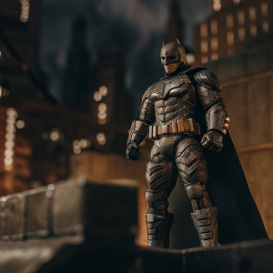 Batman action figure from 'Batman v Superman: Dawn of Justice'. Dark base with Gotham city backdrop. Dynamic pose, intricate armor design.