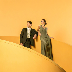 Javier Zanetti and Paula de la Fuente Zanetti at a corporate gala. Elegant attire, dark wooden backdrop.