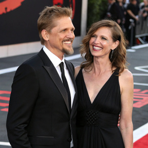 Barry Pepper and Cindy, smiling at the premiere. Wearing formal attire. Black and white carpet with red carpet accents.