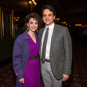 Ralph Macchio and Phyllis Fierro attending the premiere of Sea of Love at the Beekman Theatre. Inside setting with dim lights and patterned flooring. Phyllis in a purple dress with structured jacket and Ralph in a gray tweed blazer, white shirt, and patterned tie.