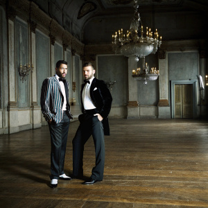 Justin Timberlake and Trace Ayala, posing at an exclusive gala. Elegant indoor setting with grand chandeliers.