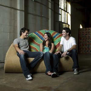 Ryan Sypek, Genevieve Cortese, and Micah Alberti at the ABC Family event. Wearing casual outfits against a vibrant, colorful backdrop.