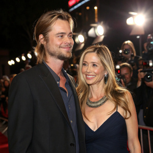 Christopher Backus and Mira Sorvino at the premiere of a new film. Bright lights and paparazzi in the background.