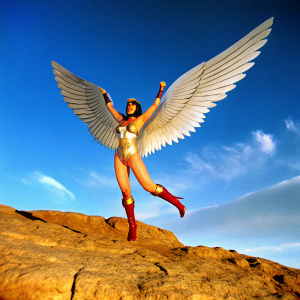 Digital artwork featuring Darna, a female superhero. Flying gracefully, determined look. Costume includes gold and white material, red boots. Against stark blue backdrop