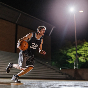 Christian Laettner, wearing jersey number 32, plays intense one-on-one basketball game under spotlight. Dynamic action shot.