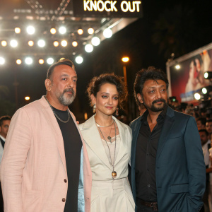 Sanjay Dutt, Kangana Ranaut, and Irrfan Khan at the Cannes Film Festival. Promoting the movie 'Knock Out'. Bright lights and crowd in the background.