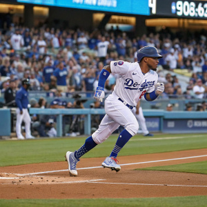 Ketel Marte in action at Dodger Stadium. Running towards first base. Crowd cheering in background.