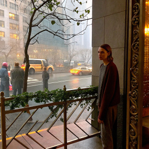 Cara Delevingne, intense gaze, casual outfit, outside in the city. Busy street in background.
