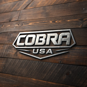 Cobra USA logo, bold, angular font on a rustic wooden plank, dark brown, metallic silver accents, modern industrial design