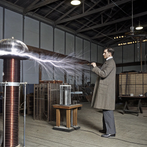 Colorized photograph of Nikola Tesla in his lab. Vibrant room with powerful electric discharge. Historical moment showcasing wireless technology experiments.