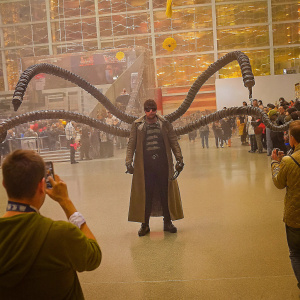 Doctor Octopus cosplayer at a Comic-Con event. Crowded venue, fans taking pictures.