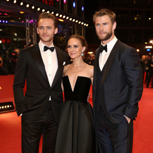 Tom Hiddleston, Natalie Portman, and Chris Hemsworth attending the Berlinale premiere. They wear formal attire against a red carpet backdrop.