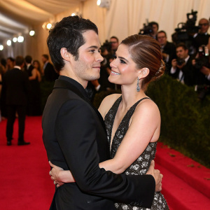 Dylan O'Brien and Kate Mara at the Met Gala. They're embracing on the red carpet, with paparazzi and celebrities in the background.