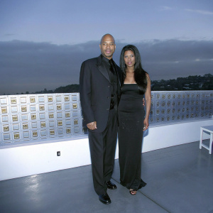 John Ridley, bald with stubble, and Gayle Ridley, with long dark hair, at a Human Rights Campaign event. They are dressed formally and pose in front of a backdrop filled with the organization's logos.