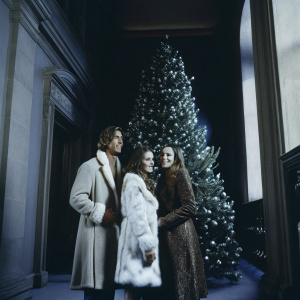 Jay Rutland, Sophia Ecclestone, and Tamara Ecclestone gathered around a grand Christmas tree. The siblings, adorned in stylish fur-trimmed coats, pose for a family portrait. Jay's coat is dark while Tamara's is brown, creating a cozy holiday scene.