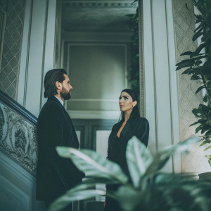 Kourtney Kardashian and Scott Disick captured at a private event. Luxurious interior with rich green plants. Formal attire.