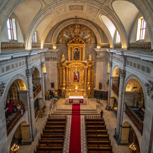 Aerial view of Our Lady of the Candelaria church. Ornate golden altar stands in the center, surrounded by intricate sculptures and red runner.
