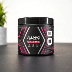Close-up of Allmax Nutrition Razor 8 pre-workout container. Black with pink and white accents. Product info prominently displayed.