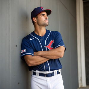 Luke Maile, Cleveland Guardians player, standing confidently in a blue jersey with white trim. Simple gray backdrop.