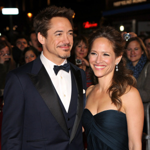 Robert Downey Jr and Susan Downey attending the premiere of Sherlock Holmes. Formal attire. Crowded theater event.