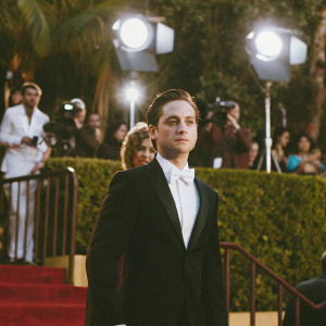 Tobey Maguire, with intense gaze and slicked-back hairstyle, at a glamorous award show.