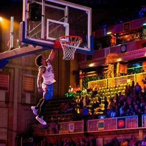 Quentin Grimes mid-dunk at the NBA All-Star Game. He wears the New York Knicks jersey. Crowds cheering in the background.