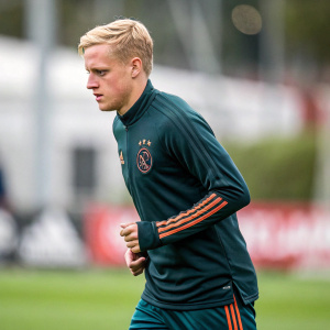 Donny van de Beek at Ajax Amsterdam training. Dark green jersey with team emblem. Sporty attire, focused expression.