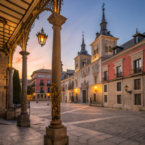 In the bustling heart of Madrid, the Plaza de la Villa stands as a testament to Baroque elegance. Under the golden glow of twilight, the detailed ironwork and ornate pillars come alive, showcasing the city's rich history. The vibrant colors of the setting sun paint the ancient stones in a breathtaking display of warm hues, inviting passersby to wander through the labyrinthine pathways and explore the hidden stories of the past.