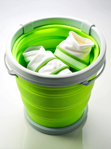 green round folding silicone bucket with white sides, with T-shirts and socks inside