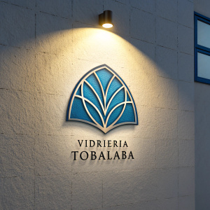 The logo for Vidrieria Tobalaba, a blend of sleek blue geometry and understated elegance. A soft glow illuminates the emblem, casting shadows that highlight the name 'Vidrieria Tobalaba'.