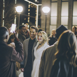 Group photo featuring Tahj Mowry, Chelsea Kane, Jean-Luc Bilodeau, Melissa Peterman, and Derek Theler at the premiere party. Crowded and vibrant event setting with flashing lights