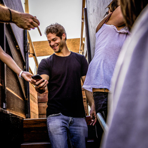 Tyler Posey at the Music Awards, dressed in a casual black t-shirt and jeans. Hanging out with fans, signing autographs.