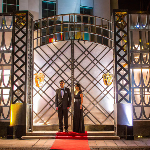 Louis Theroux and Nancy Strang attending a gala. Red carpet event with BAFTA and Virgin Media logos. White backdrop with intricate design.