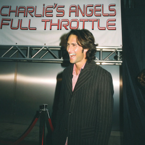 Rodrigo Santoro, at 'Charlie's Angels: Full Throttle' premiere, Hollywood, California. White backdrop with red event text. Broad smile, warm Caucasian ethnicity, medium-length wavy brown hair, dark pinstriped blazer, pinkish shirt.